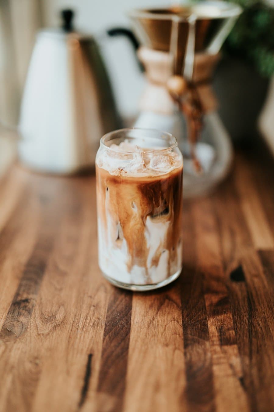 An iced latte in a glass on a wooden counter