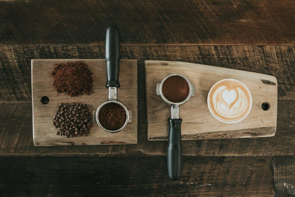 Portafilters with freshly ground coffee on a wooden board