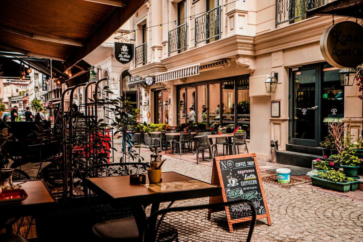 The café terrace on a quiet street with tables and a chalkboard menu